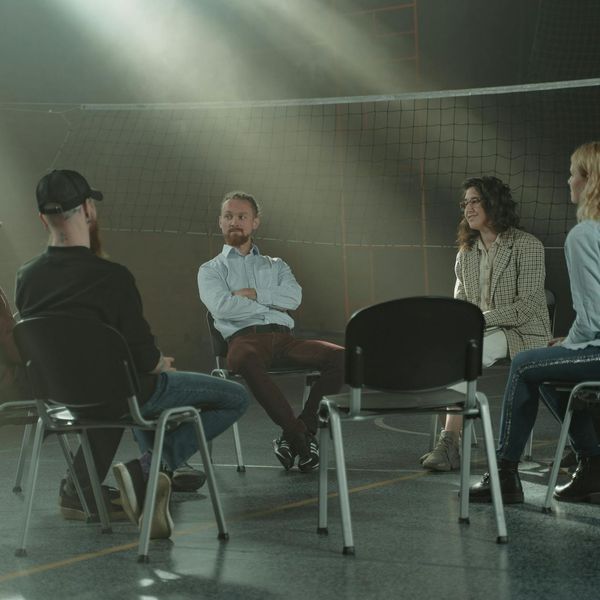 Group of people talking and laughing after a workout session.