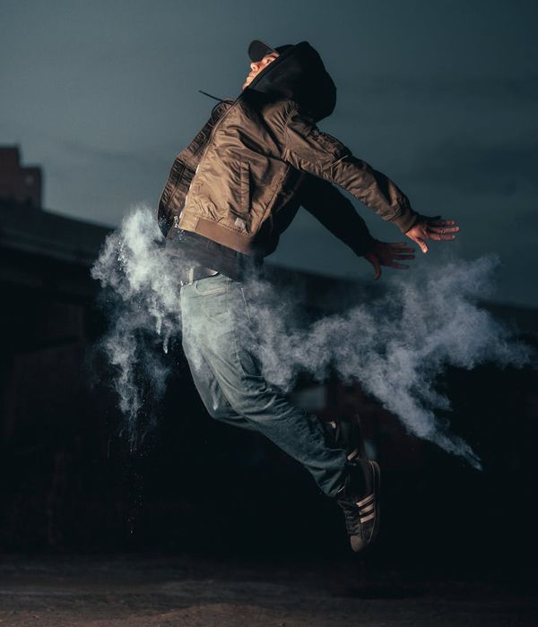 Person in mid-jump, showing energetic movement against a dark background.