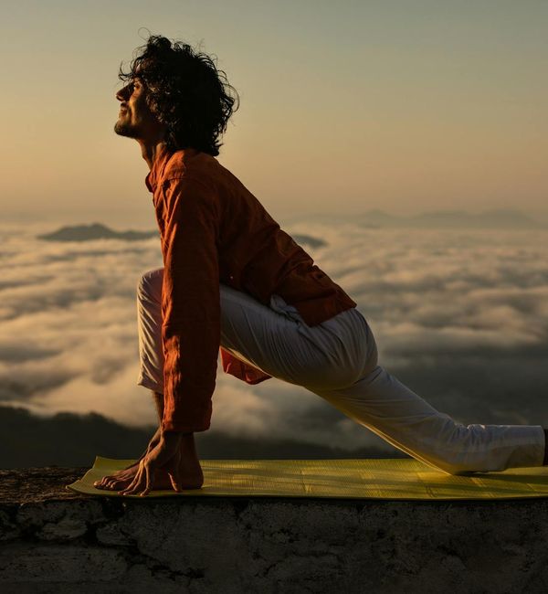 Silhouette of a person stretching against a sunrise, feeling revitalized.